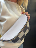 Person wearing a checkered fanny pack with a plain background