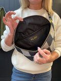 Person holding a checkered handbag with a visible brand label.