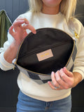Person holding a checkered bag with a visible brand label.